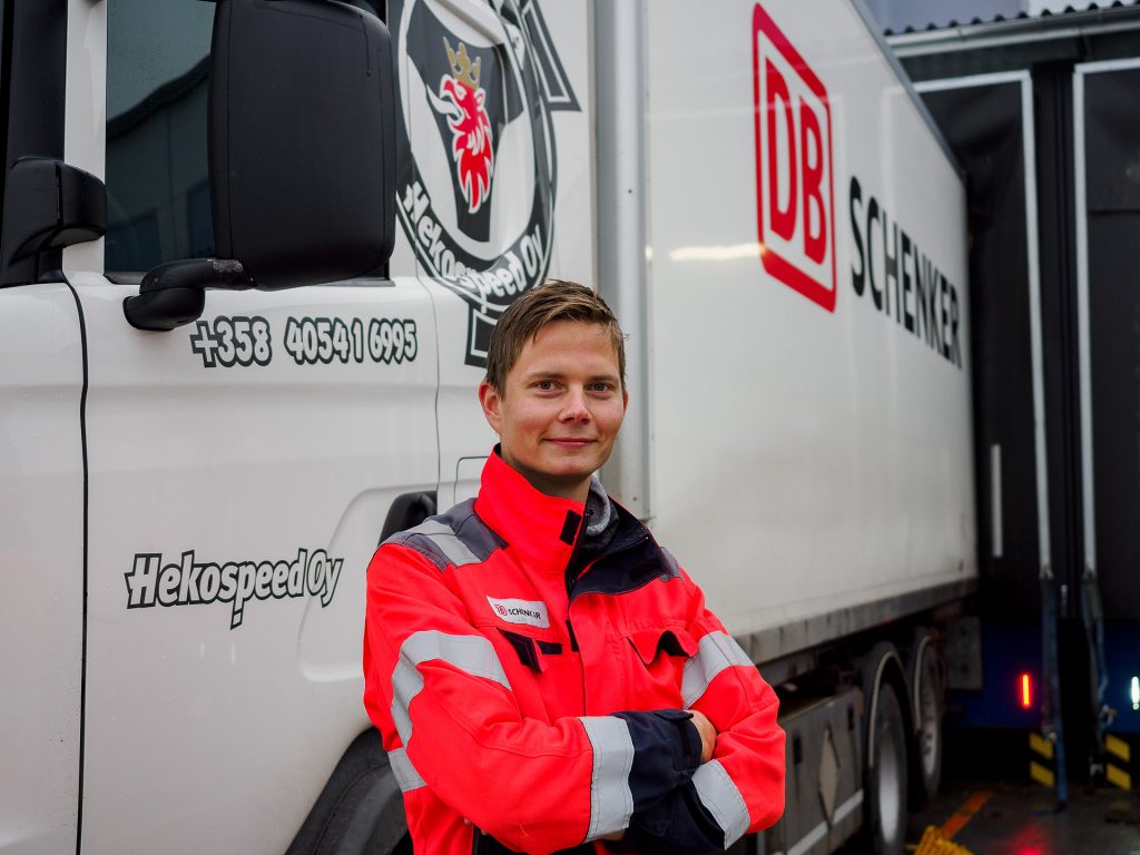 Eero Korpinen seisoo DB Schenkerin tarroilla varustetun Hekospeed Oy:n ajoneuvon edessä.