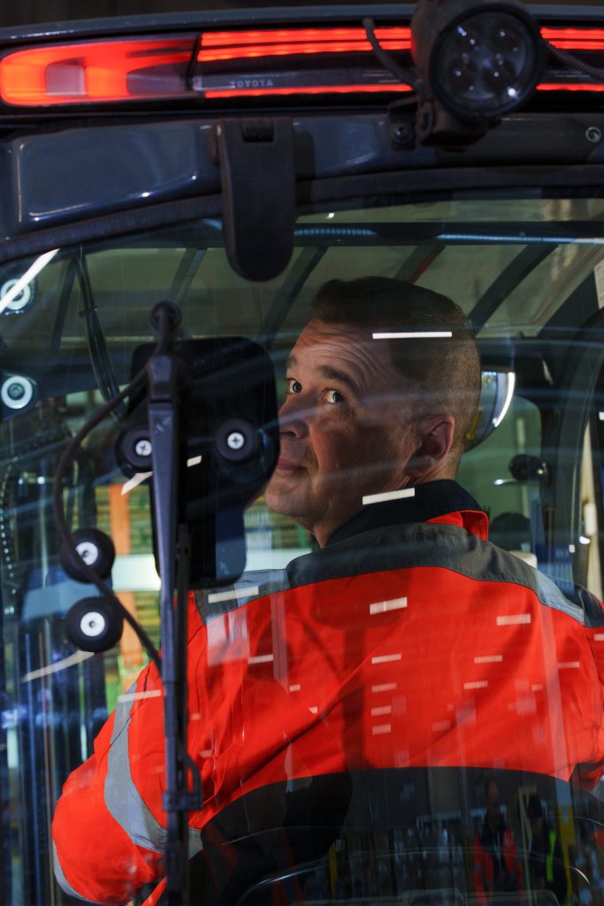DB Schenkerin kuljettaja Marko Tuovinen katsoo trukin takaikkunasta.