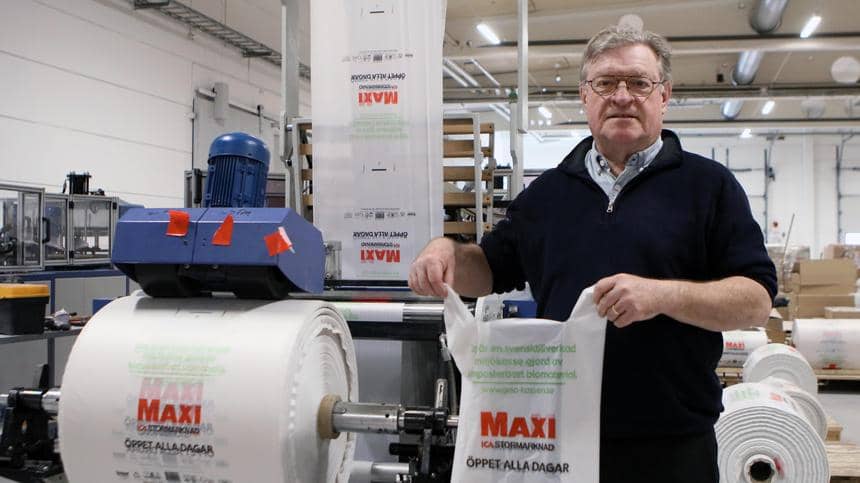 Åke Rosén, vd på Gaia Biomaterials visar upp en påse med ICA Maxi-logo på en maskinfabrik. 