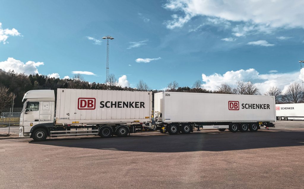 Vit lastbil med flak och logotypen DB Schenker.